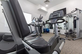 A gym with treadmills, elliptical machines, and other exercise equipment.